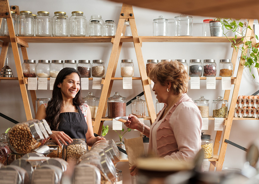 Hispanic employee happily helping elder female customer