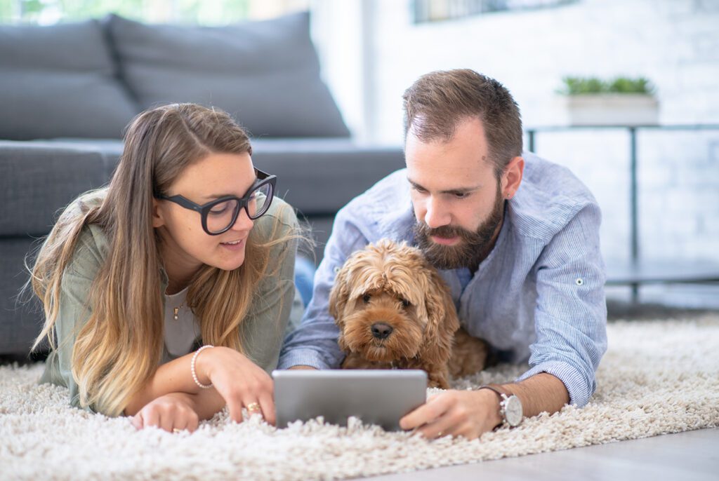 A couple with their dog reviewing finances together