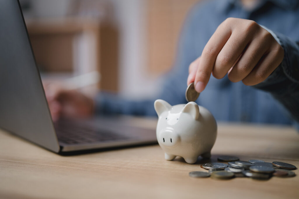 Person putting money in a piggy bank